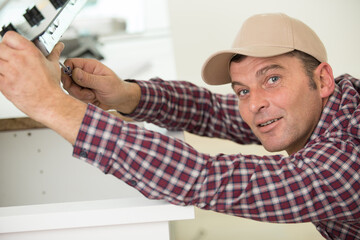 repairman examining stove in the kitchen