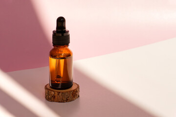 Banner of cosmetic amber glass dropper bottle on wooden podium with oil, serum or fruit peeling in...
