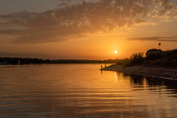Fototapeta na wymiar Beautiful bright dramatic sunset over the river