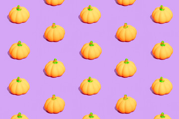 Seamless pattern made of little pumpkins on purple background. Minimal autumn, Halloween or Thanksgiving  composition.