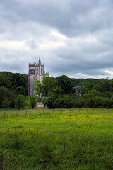 Fototapeta premium St Nicolas tower in the Notre-Dame du Bec Benedictine abbey on a cloudy spring afternoon, Le Bec-Hellouin, Normandy, France