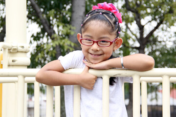 Obraz premium Little brunette latin woman girl with glasses plays outdoors in free games, happy, doing physical activity