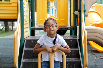 Little brunette latin woman girl with glasses plays outdoors in free games, happy, doing physical activity