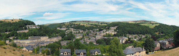 Fototapeta na wymiar panoramic view of hebden bridge showing streets and the town centre surrounded by pennine countryside in summer sunlight