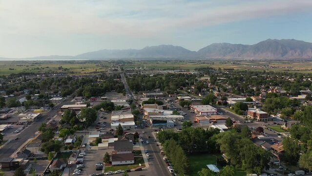 Aerial drone shot of Main Street in rural American town with farms and mountains