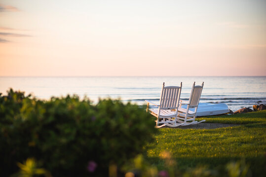 Empty Outdoor Rocking Chairs at coastal summer sunrise