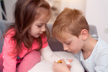 River fracture in a child. Brother and sister draw on plaster, bandages.