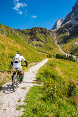 Naklejka premium Amateur cyclist traveling the Rolle Pass in San Martino di Castrozza, Trentino Alto Adige - Italy