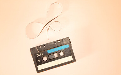 Transparent broken cassette tape on pink background