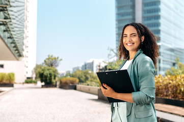 Successful positive confident young brazilian or hispanic curly haired business woman, real estate...