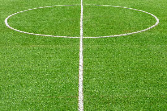 A fragment of the marking of a football field with green grass.