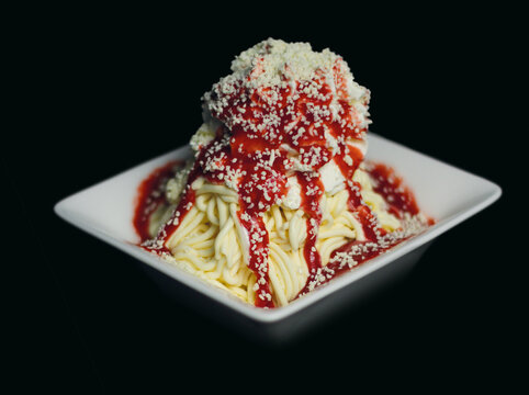 Ein k&ouml;stliches Spaghetti Eis vor schwarzem Hintergrund mit Tiefenunsch&auml;rfe. Ideal als Produktbild f&uuml;r Eiscafe oder Speisekarten