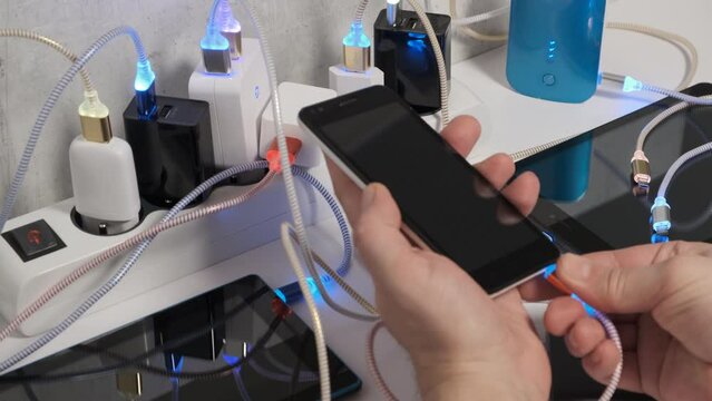 Connect Smartphone Mobile Phone and tablets connected to Charging hub on the Table, micro usb   wires to chargers in sockets with LED light Blinking. Extension cord switch loaded with Charger 
