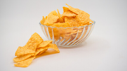 Delicious nachos chips on the glass bowl, isolated on white background