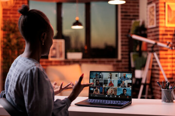 Corporate worker talking with remote team on business meeting using laptop, back view. Company colleagues brainstorming on teleconference, freelancing and telework concept