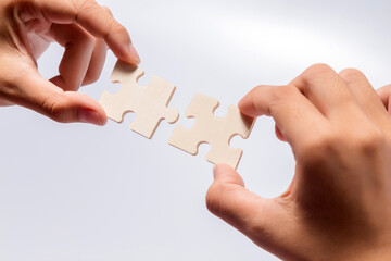 Pieces of jigsaw puzzle in woman's hands