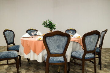 Seating layout of a wedding with a round bridal table in the centre of a colonial dining room with white sheer ceiling drapes.