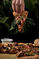 primer plano de mano de una mujer sosteniendo una rebanada de pizza 