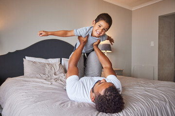 Smile, love and happy father and son family time playing in bedroom bed lifting him like airplane...