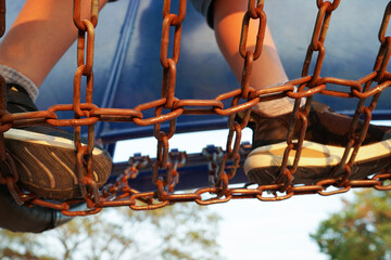 公園で遊ぶ男の子。コンビネーション遊具の渡橋部分、複合遊具。夏休み
