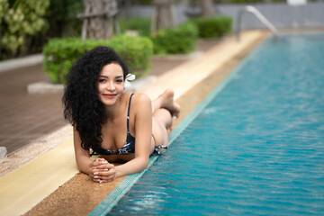  woman in the bikini at pool Swimming pool tanned slim and shapely body, Girl enjoying travel holidays at resort luxury overwater bungalow