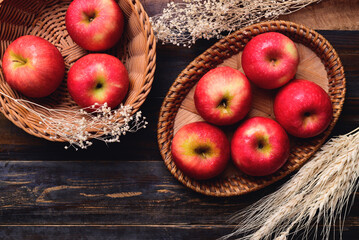 Red apple fruit in basket on wooden background, Table top view