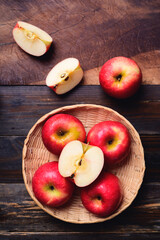 Red apple fruit in basket on wooden background, Table top view