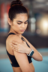 Fototapeta na wymiar Injury, hurt and shoulder pain for a female athlete holding her painful arm at the gym. Active, fit and athletic woman suffering from muscle inflammation due to an exercise or workout