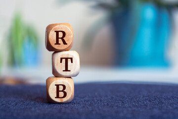 Tower made of cubes and dice with acronym RTB - Real Time Bidding - on wooden background