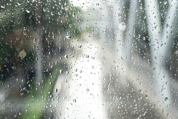 Morning city,view through the window on rainy day. Water droplets on the glass on a rainy day. rain drops during raining in rainy day outside window glass with blurred background.