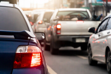 Rear side of blue car on the roads. Turn on brake light with other cars. Traffic congestion during working hours or during rush hours. 