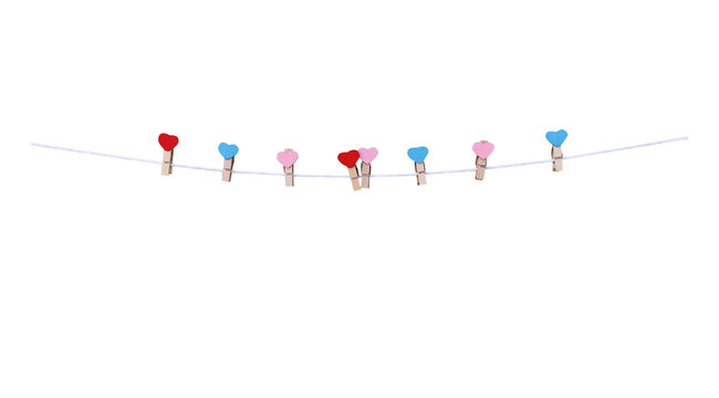 Eight wood clothes clip with red pink blue heart shape patterns hanging on white string line isolated on white background , clipping path