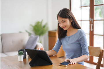 Work from home concept, Business women reads financial data on tablet to working in living room