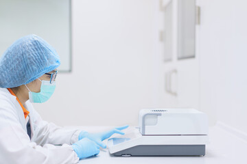 Unidentified operator or chemist is testing moisture or water content in sample with automatic...