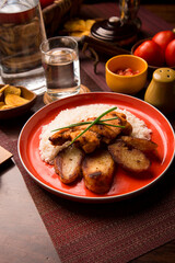 Fried chicken stew with baked potatoes Peruvian comfort restaurant gourmet food