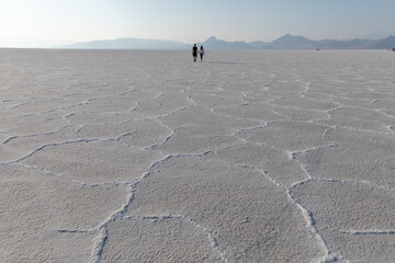 Young couple holding hands walking on Bonneville Salt Flats in Utah