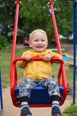 Happy boy on swings at playground