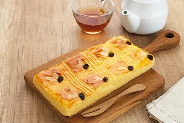 Deurstickers Lekker holland or dutch butter cake (boterkoek), made of butter, flour, eggs and sugar with a sprinkling of sliced ​​almonds and raisins  © Tyas Indayanti