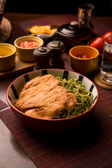 Green sauce pesto spaguetti noodles pasta with breaded chicken filet Peruvian comfort restaurant gourmet food