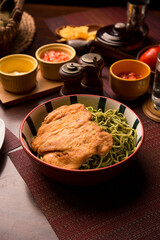 Green sauce pesto spaguetti noodles pasta with breaded chicken filet Peruvian comfort restaurant gourmet food