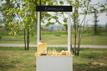 Wooden kiosk with lemonade and lemons, children's decorations in the park