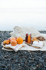 Picnic on the lake shore, a blanket with a basket, fruit and juice