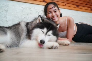 Young woman with her dog at modern house on nature light.