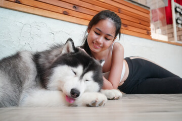 Young woman with her dog at modern house on nature light.