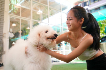 Young woman with her dog at modern house on nature light.