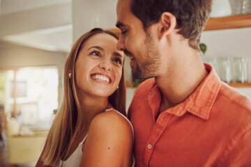 Couple, smiling and in love having a lovely romantic moment in the kitchen at home. Man and woman...