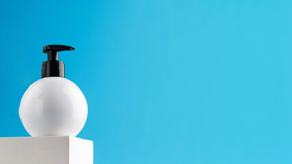 Mockup of a white dispenser with a cosmetic product with a place for your logo on a podium on a blue background.
