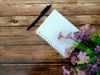pink flowers and  notebook on table