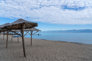 Sandy beach with wooden umbrellas
