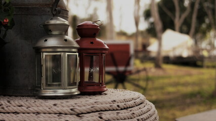 Vintage gasoline oil lantern lamp burning with a soft glow light in an dark forest / wood. Light in the darkness. Travel Outdoor Concept